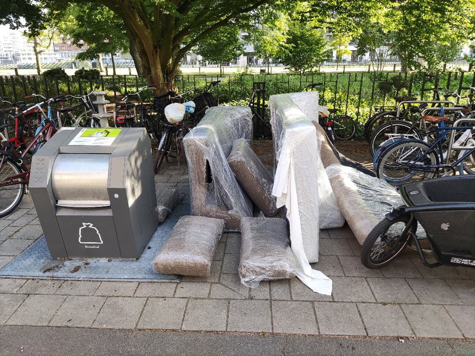 Shrink-wrapped corner sofa, presumably in good condition.