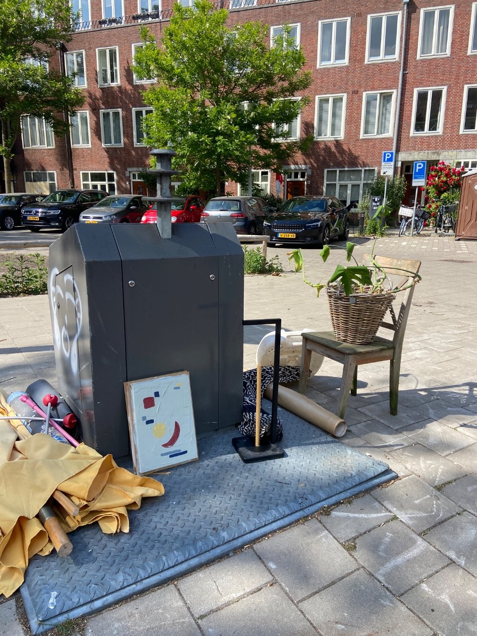 Wooden chair, wicker basket, monsters plant and a little artwork.