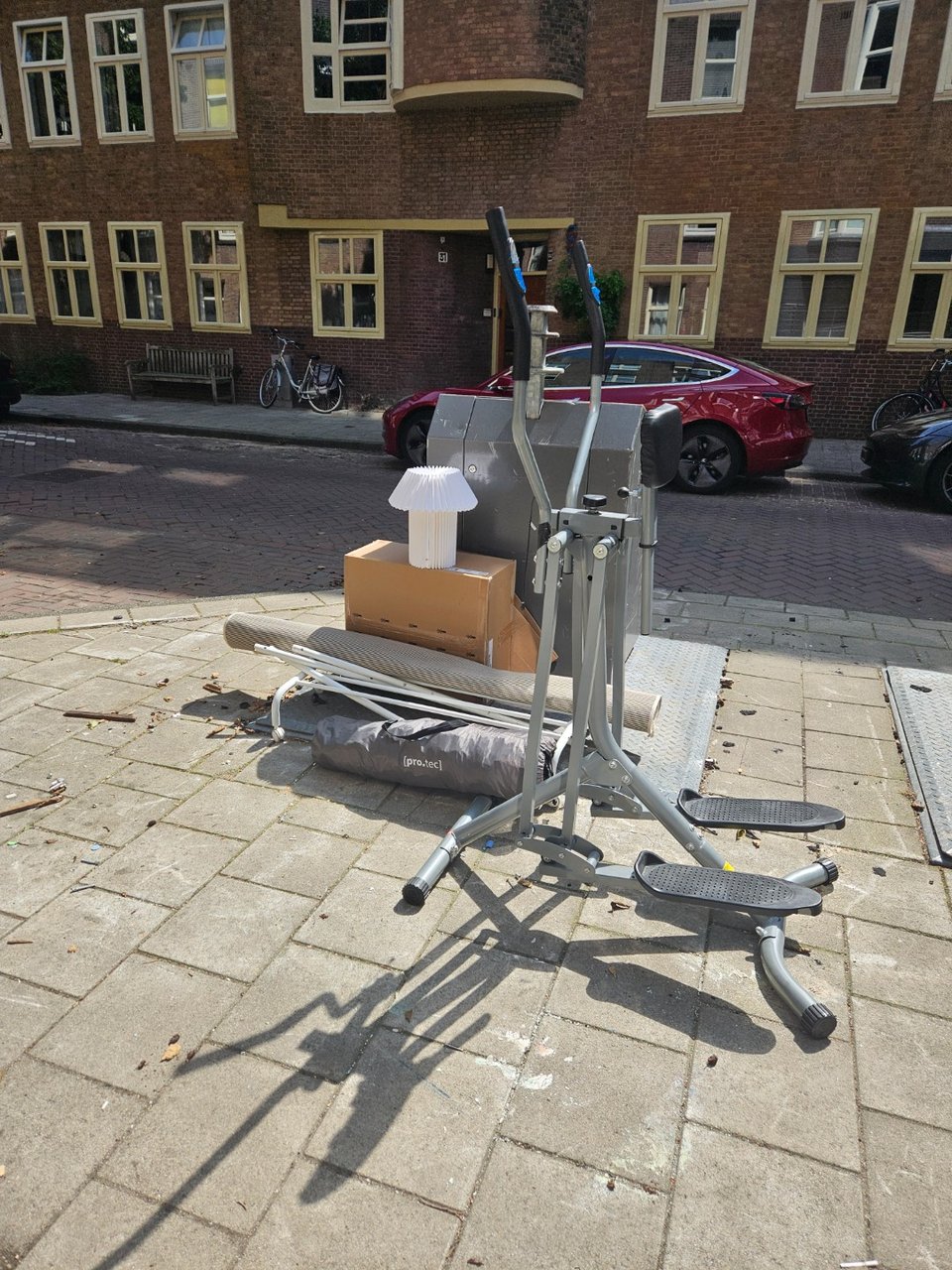 Assorted items: Rug, lamp, cross trainer, clothing rack.