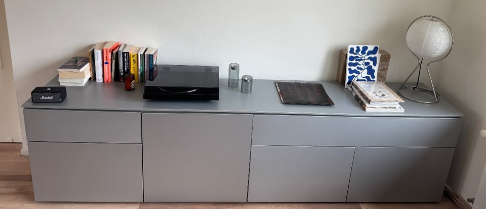 Dressoir in zilver. 253 lengte, 45 diepte. 65 hoogte. 1 kleine en 1 grote lade. 4 kasten met interne planken.

Lichte beschadigingen aan de voor- en achterhoeken, kan worden overschilderd met kleur RAL9006.