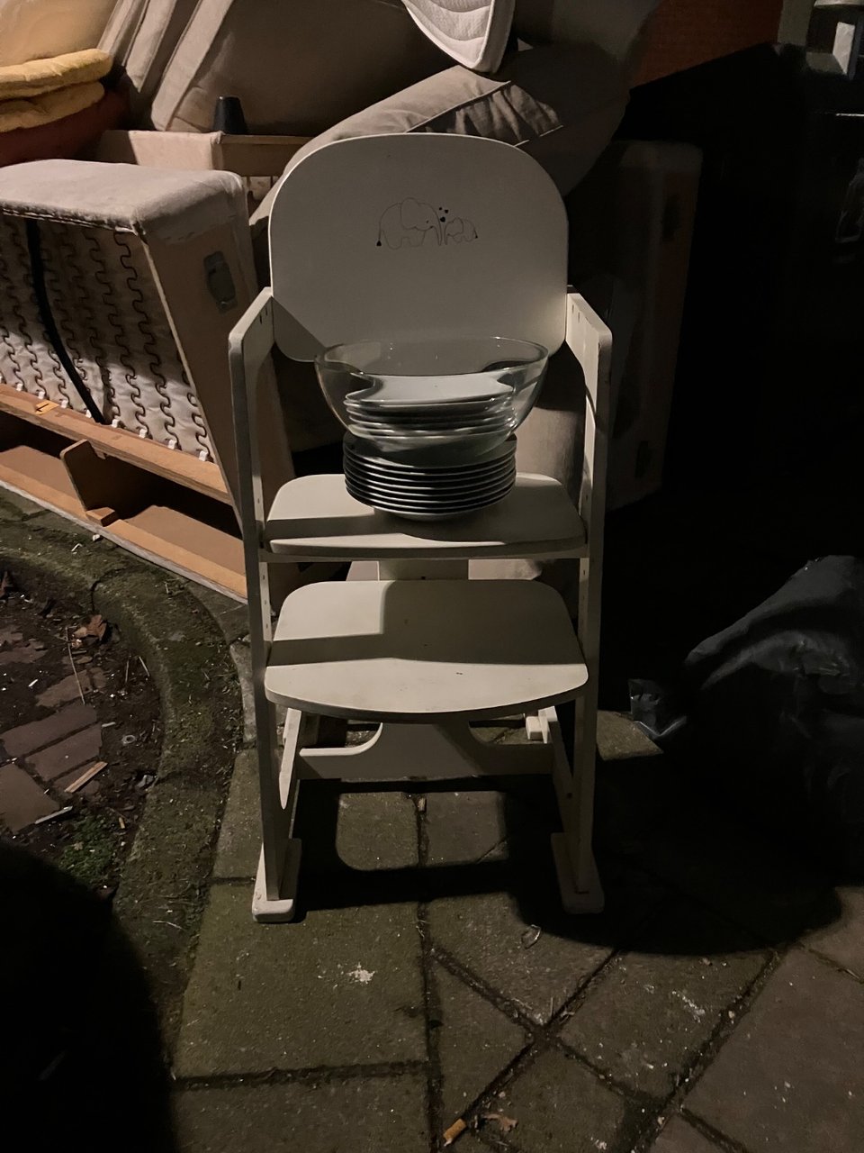 Next to the containers opposite Kuinderstraat 7. Children’s chair and a pile of small white places.