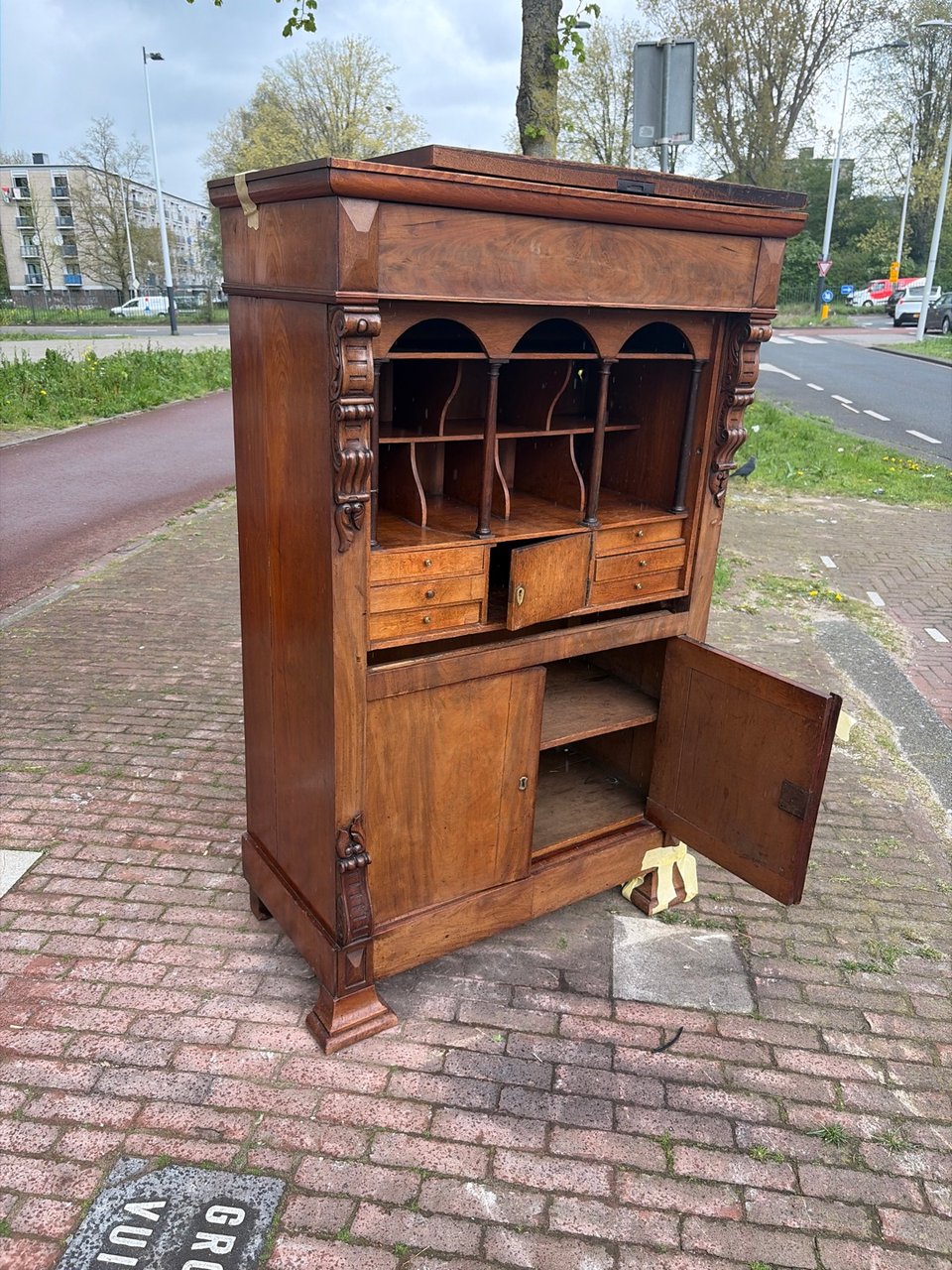There is a beautiful-looking wooden cupboard by the road; some panels are off, but I think it's easily mendable.
